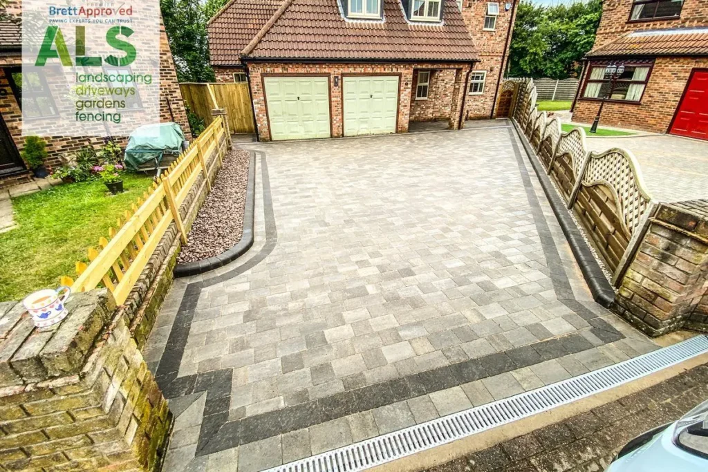 Silver block-paved driveway with charcoal border and a kerbed red-chip bed