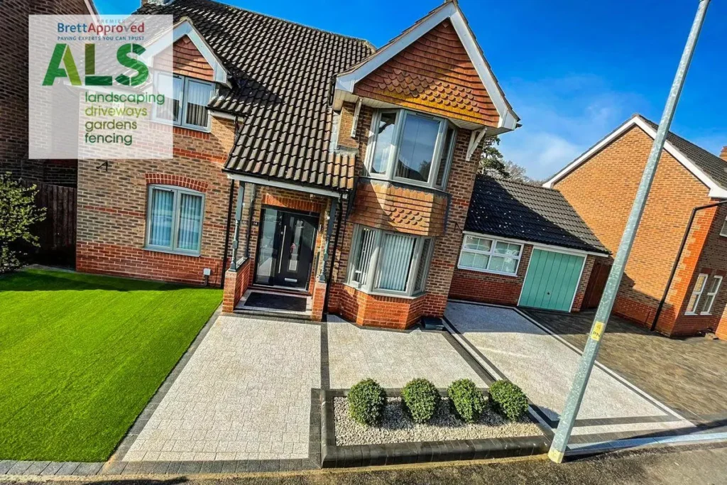 Red-brick house with a new silver-grey block-paved drive, path and topiary bed