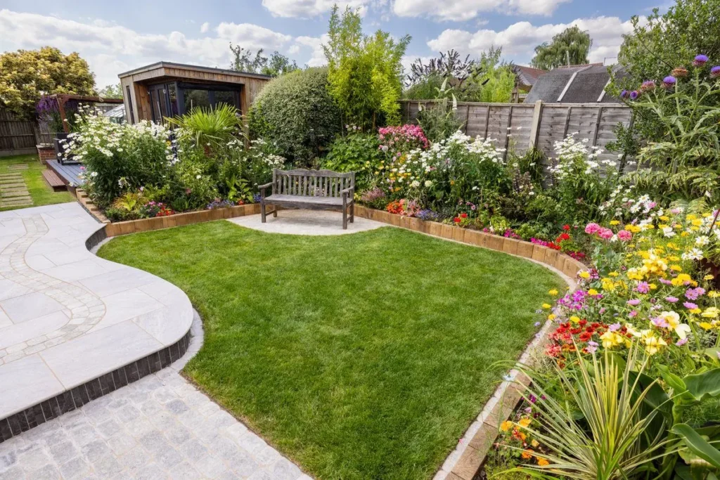 Curved light porcelain path with a dark-edged step wrapping a shaped lawn and flower borders